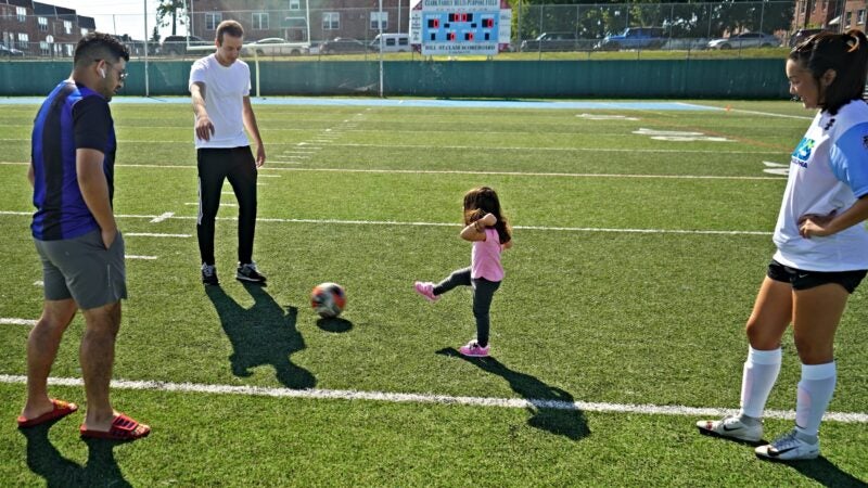 A little girl kicks a soccer ball