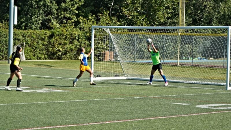 The goalkeeper for the Brazilian women's Unity Cup team jumps up to block a goal