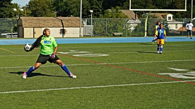 A goalkeeper throws the soccer ball