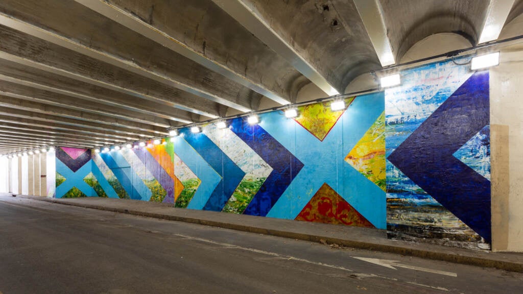 mural running along a wall inside a tunnel