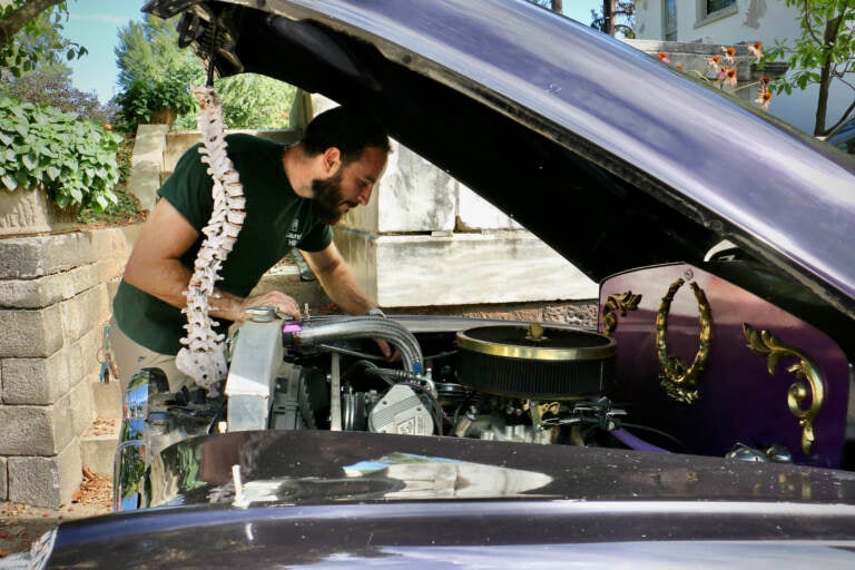 Laurel Hill Cemetery mechanic Ed Bernstein checks under the hood of the 1947 Pontiac Superior hearse, FYNLRYD