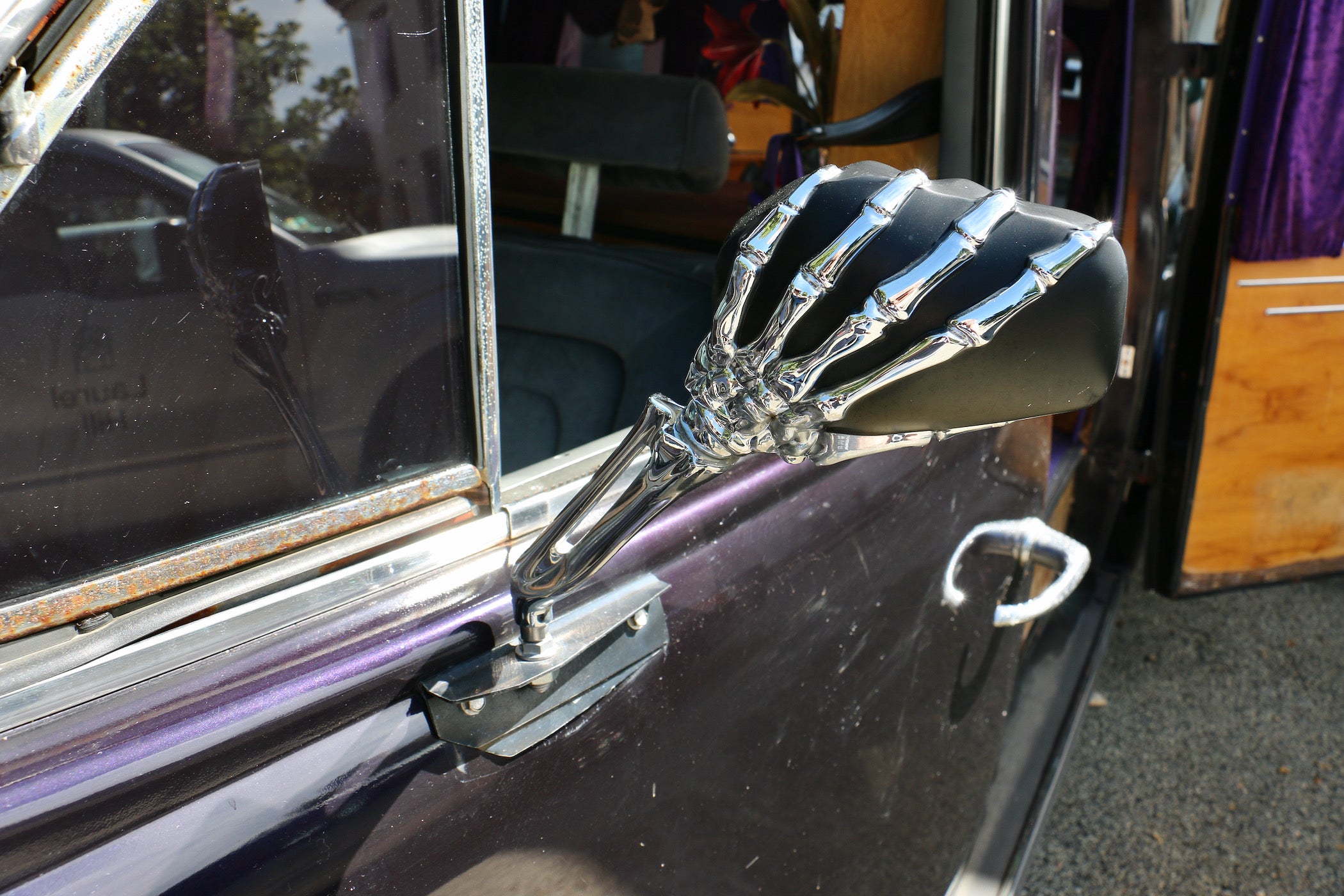 A skeletal chrome hand holds the rear view mirror