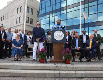 Marty Small speaking at a podium, with other officials