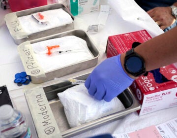 Syringes with vaccines are prepared at the L.A. Care and Blue Shield of California Promise Health Plans' Community Resource Center where they were offering members and the public free flu and COVID-19 vaccines Oct. 28, 2022, in Lynwood, Calif. Updated COVID-19 vaccines in the latter half of 2023 come just in time to pair them with flu shots. (AP Photo/Mark J. Terrill, File)