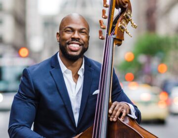 Joseph Conyers poses with a bass in front of Philadelphia City Hall.