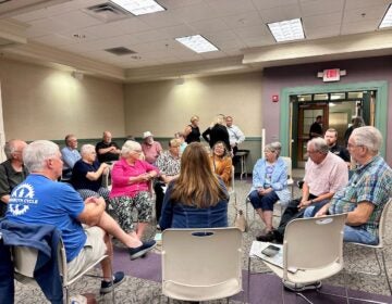 People sit together in a circle at a town hall.