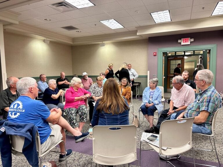 People sit together in a circle at a town hall.