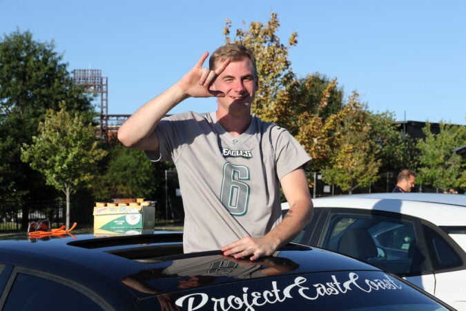 An Eagles fan waves hello from his car