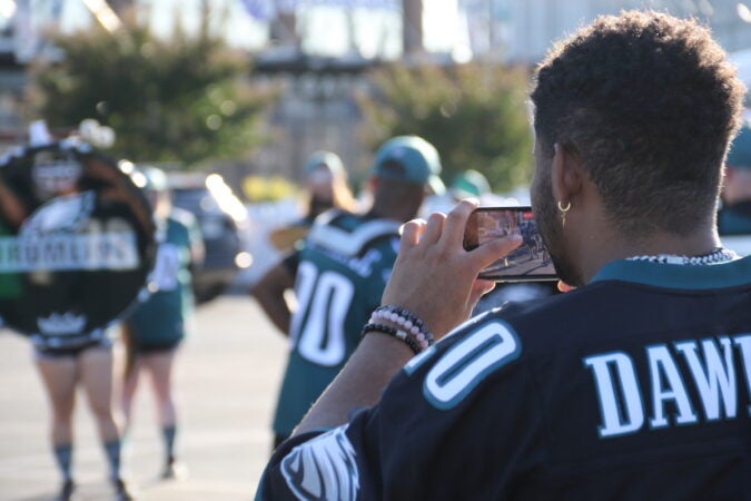 A fan films the Eagles Drumline on his phone.