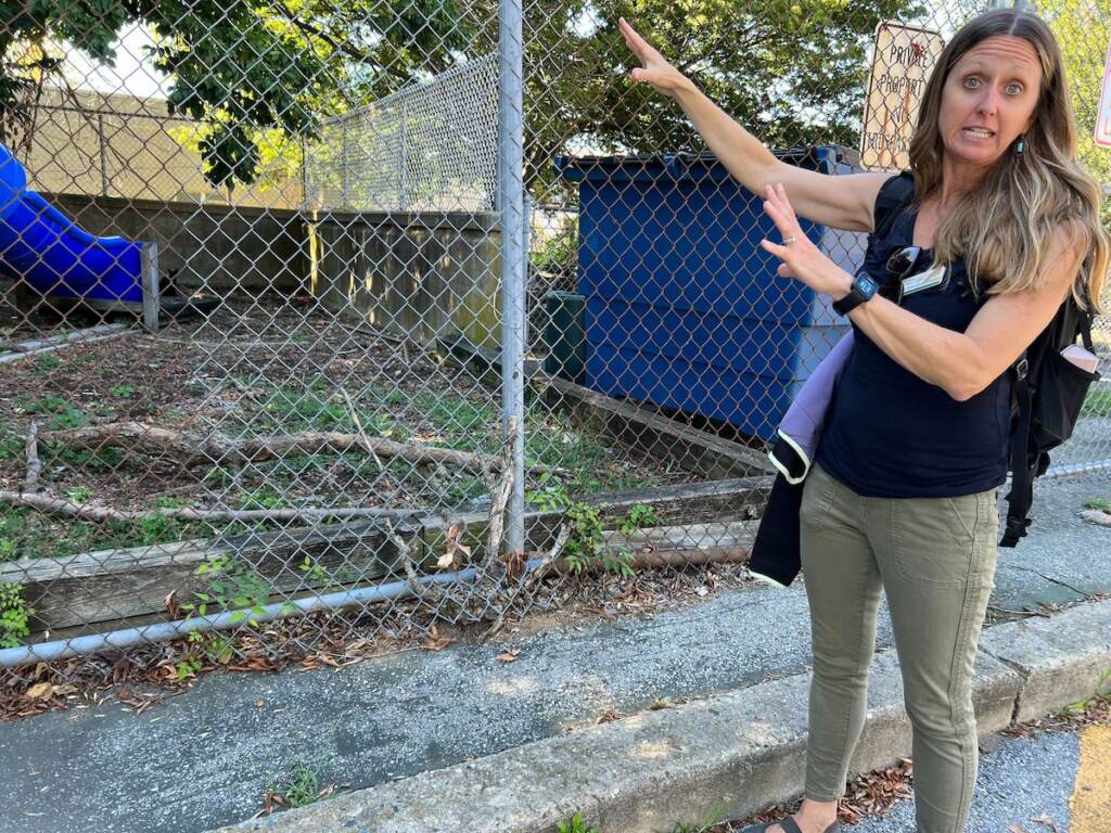 Kerry Wilson points toward a fenced-in area