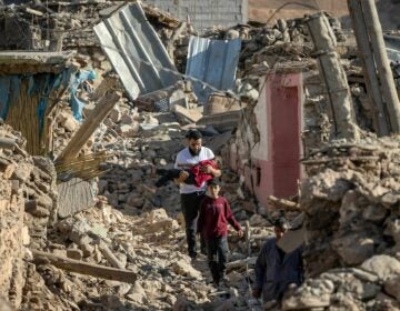 People walk past destroyed houses after an earthquake in the mountain village of Tafeghaghte, southwest of the city of Marrakech, on Saturday.