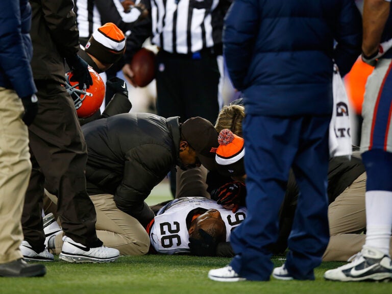 Willis McGahee, No. 26 of the Cleveland Browns, is tended to on the field in the fourth quarter of a game against the New England Patriots at Gillette Stadium in Foxboro, Mass., on Dec. 8, 2013,