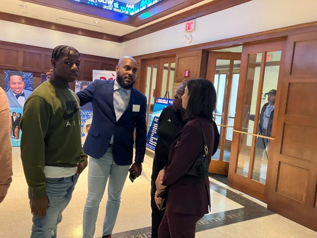 Kyseem Nickol, 15, talks to G Lamar Stewart of the District Attorney’s Office and incoming City Councilmember Rue Landau at a crime summit at St. Joseph’s University.