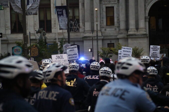 Police officers on bikes behind protesters.