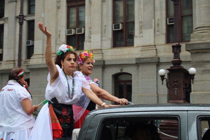 Participants saluted spectators from the back of a pickup truck as the parade made its way around City Hall. (Emily Neil/WHYY)