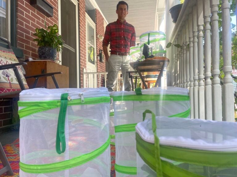Jason Hoover on his front porch with various mesh cages
