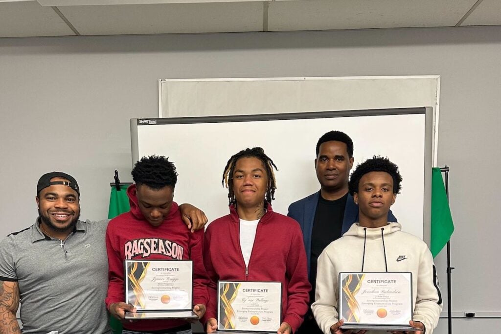 Ondre Gipson, left, poses for a photo with his students who have graduated from the "True Hustler University."