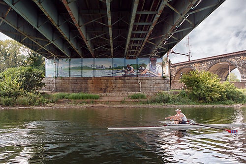 A mural underneath a bridge along a river