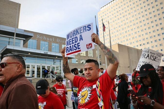 Union members hold a sign that reads 