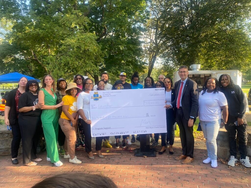 Members of West End Neighborhood House pose with a giant check representing the $300,000 award