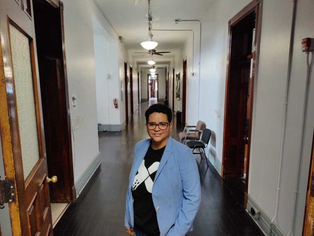 Dr. Michelle Carrera Morales poses in a hallway in a former school buidling.