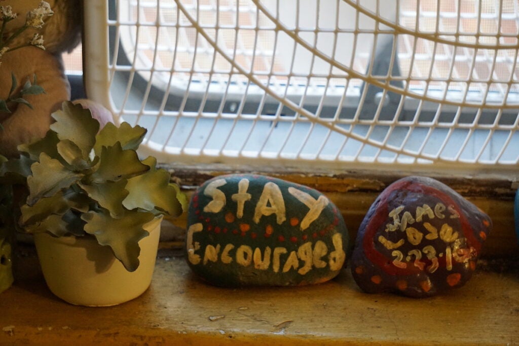 Hand painted rocks with encouraging messages sit on a windowsill.