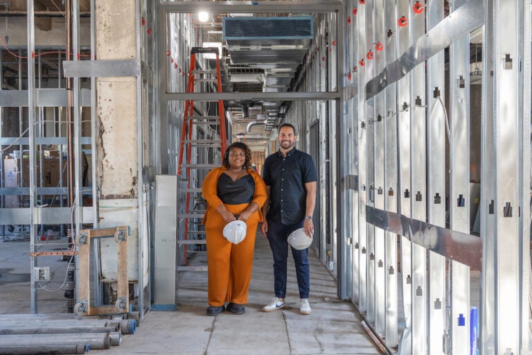 Tia Hall, left, and Alex Robles, right, pose for a photo in the building that will serve as the new home of El Centro de Estudiantes