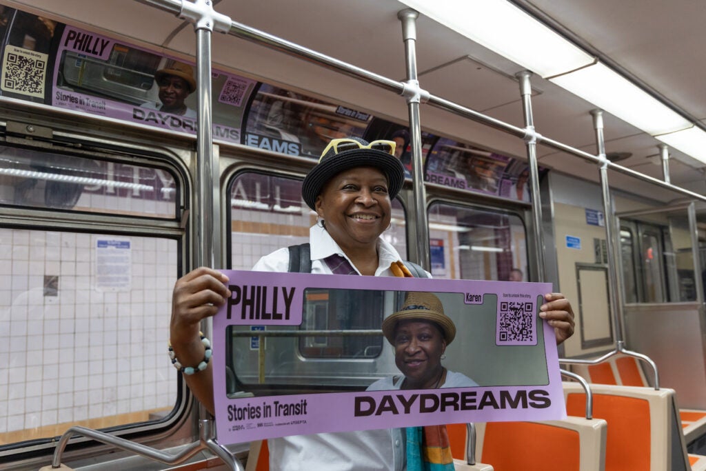 A woman holding a sign that says Philly Daydreams