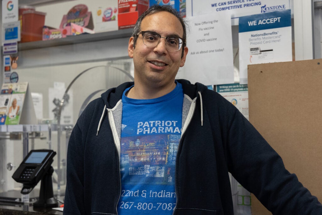 Ben Nachum posing for a photo in his pharmacy.