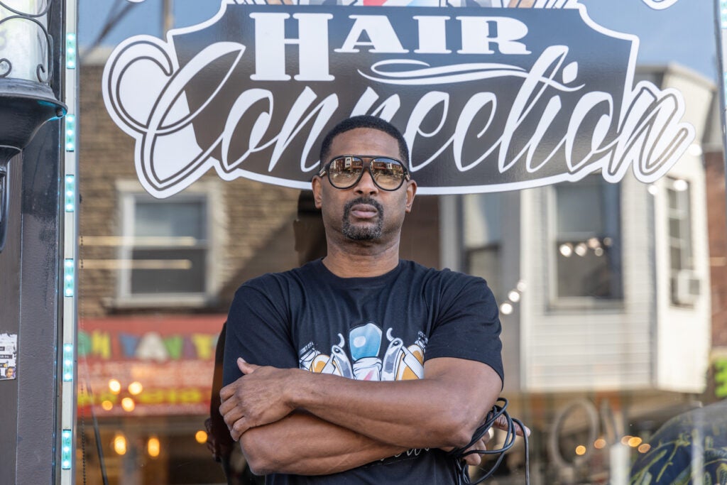 Fred Hill posing for a photo in front of his shop.