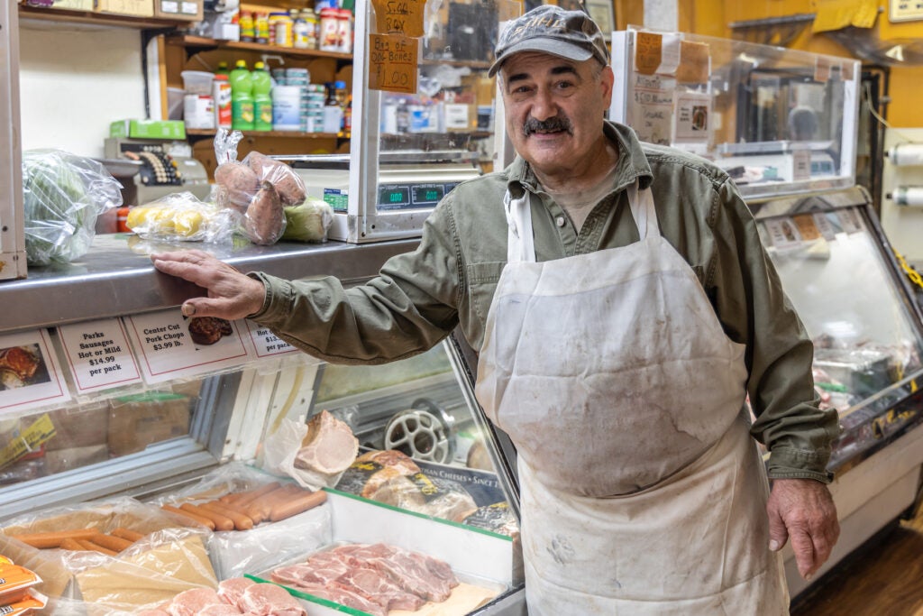 Leonard Pell posing in front of the deli counter in the market.