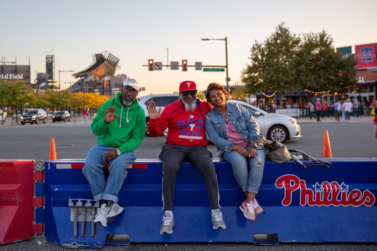 Jackie Blue (Right), Mikal Muhammad, and Rashad Muhammad enjoy the Citzens Bank Park fan tailgate before heading into Game 4 of the Phillies playoff series game on October 12 2023. (Emily Cohen for WHYY)