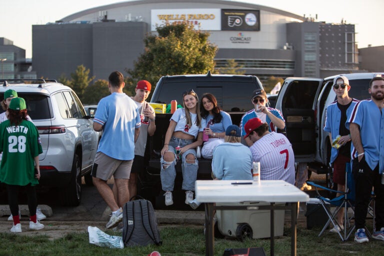 Brooke Ginley (left center) and  Ava Young tailgate with their friends from Widner University for Game 4 of the Phillies playoff series game on October 12 2023. (Emily Cohen for WHYY