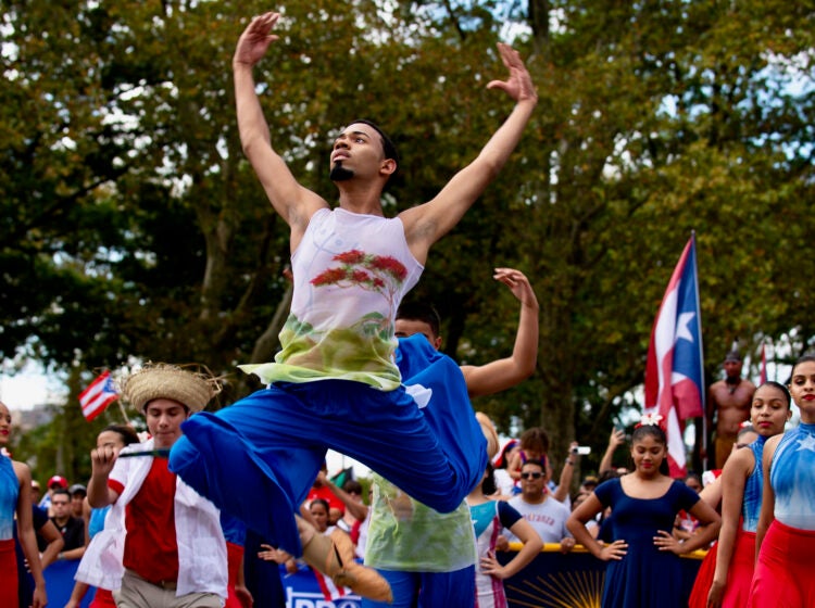 Eric Blanco leaps through the air during a dance performance as part of the Puerto Rican Day Parade