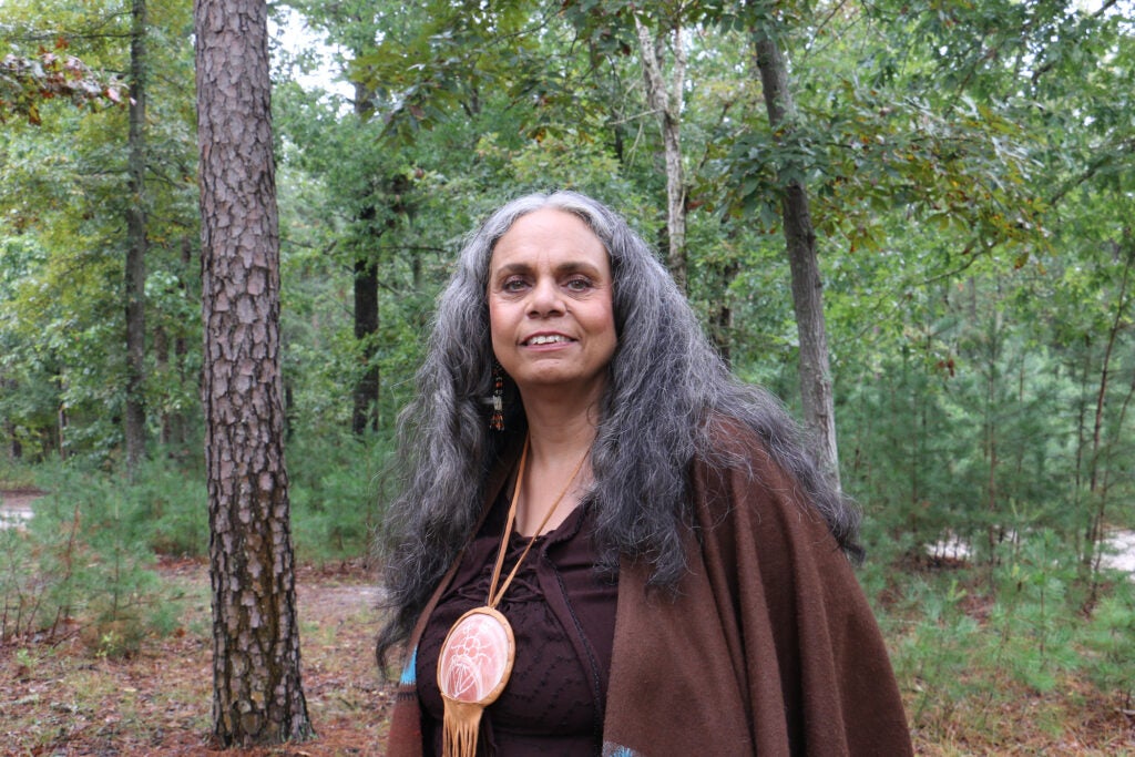 Tyrese Gould Jacinto poses for a photo in the forest.