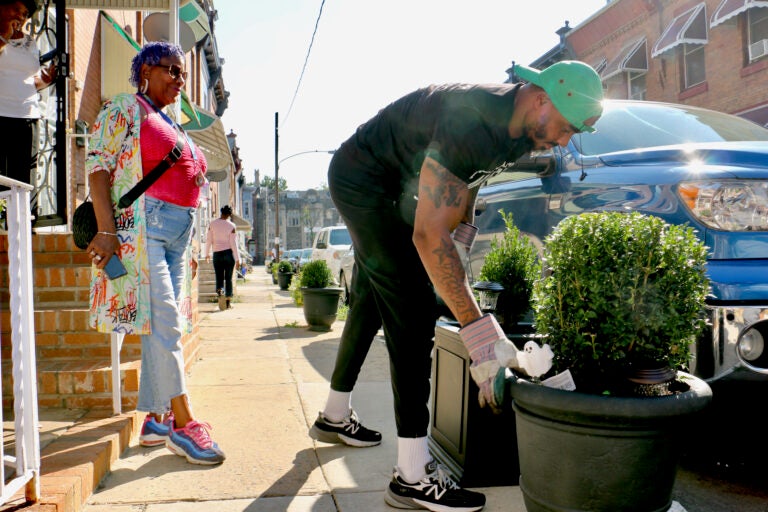 Gary Hill delivering a planter in front of someone's house.