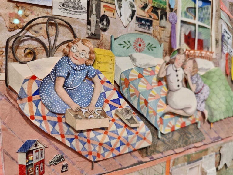 A detail from “In the home with twelve children were born and raised, where they ate and slept and laughed and loved and grew quite old” by Sophie Blackall, from her book “Farmhouse” (2022). The artist created a large paper cutout dollhouse, and over the course of the story she switched out objects to show the house slowly deteriorating over time. (Peter Crimmins/WHYY)