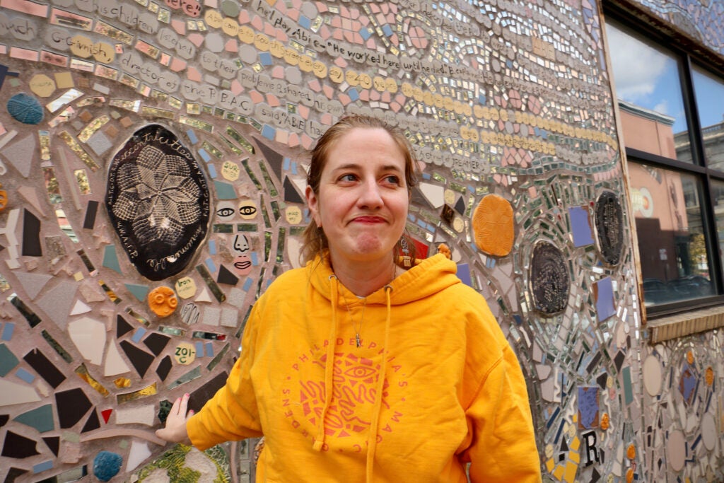 Emily Smith stands next to the mosaic at the Painted Bride