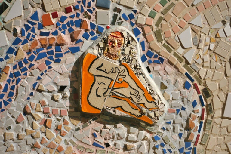 A detailed painted figure and tile on a larger mosaic