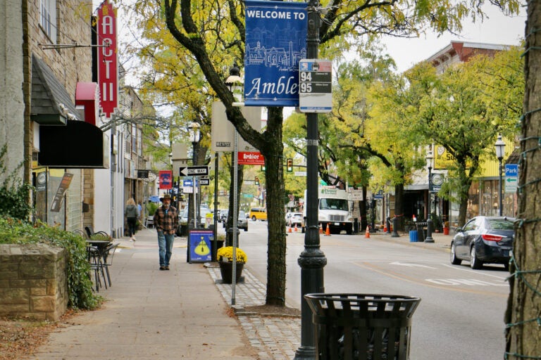 People walk down a sidewalk on Butler Ave. in Ambler, Pa.