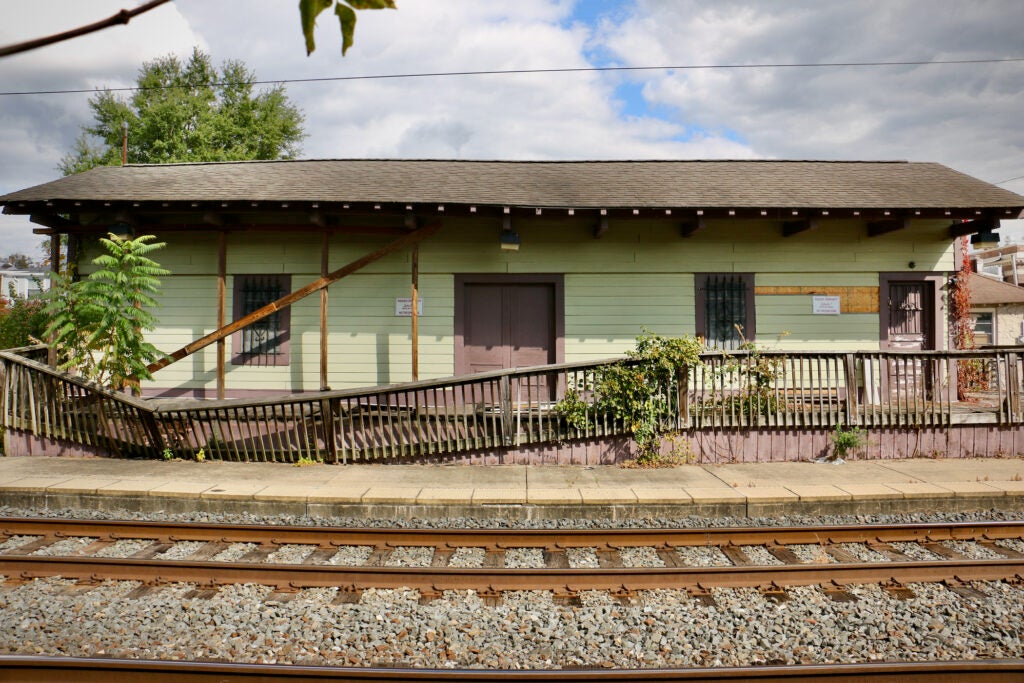 A view of the one-story Ambler Freight House next to the railroad tracks