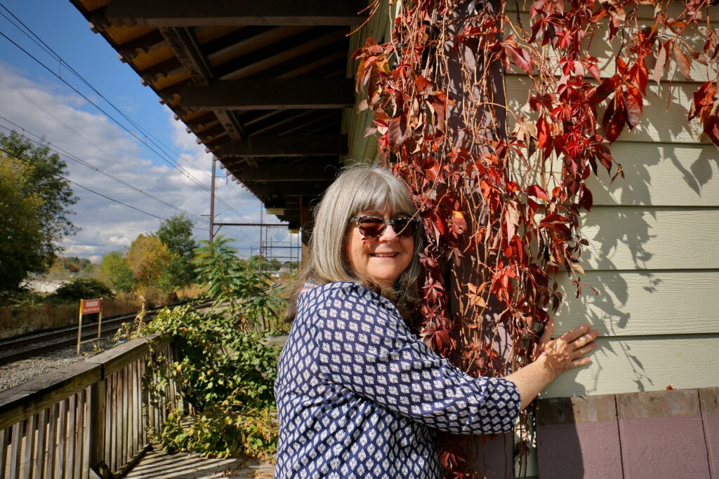 Bernadette Dougherty places a hand on the side of the Ambler Freight Station