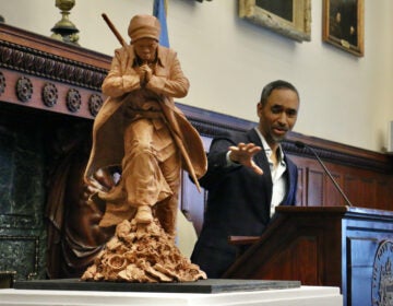 Artist Alvin Pettit talks in the background. In the foreground is his design for the Harriet Tubman statue.