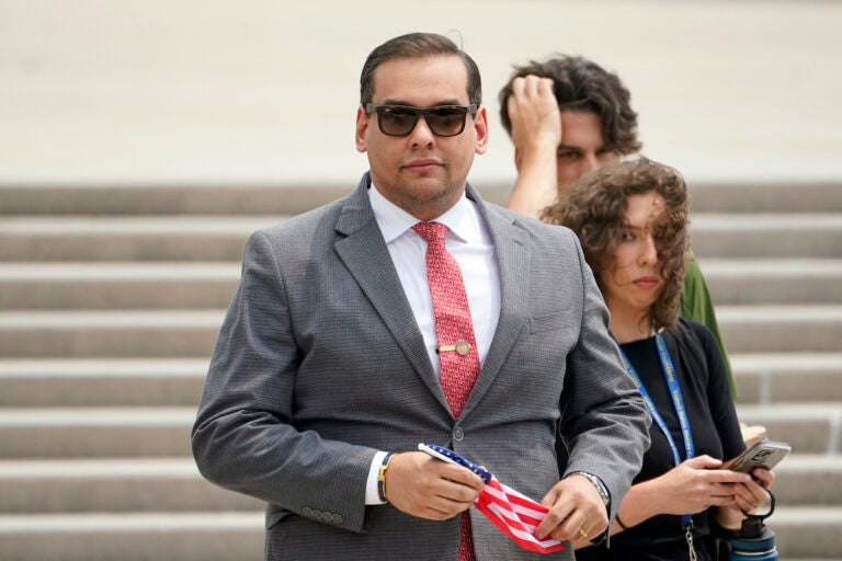 File photo: U.S. Rep. George Santos, R-N.Y., holds a miniature American flag that was presented to him as he departs federal court, June 30, 2023, in Central Islip, N.Y.