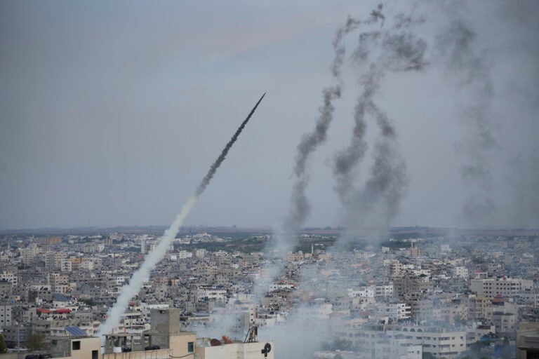 Rockets are seen in the air, after being launched across buildings