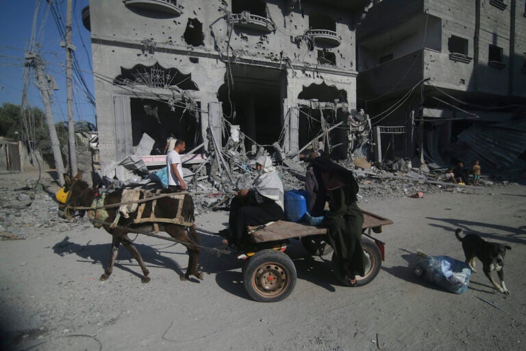 Palestinians leave their houses following Israeli airstrikes in Rafah refugee camp, southern Gaza Strip, Thursday, Oct. 12, 2023.