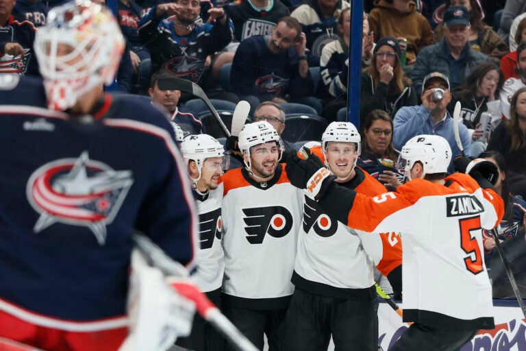 Philadelphia Flyers celebrate a goal against Columbus Blue Jackets' Elvis Merzlikins (foreground) during the first period of an NHL hockey game Thursday, Oct. 12, 2023, in Columbus, Ohio.