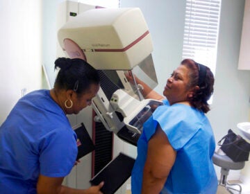 FILE -  In this May 6, 2010 file photo, detection lead mammographer, Toborcia Bedgood, left, prepares a screen-film mammography test for patient Alicia Maldonado, at The Elizabeth Center for Cancer Detection in Los Angeles. A new, international panel of experts has studied the most recent evidence on mammograms to screen for breast cancer and says they do the most good for women in their 50s and 60s. Women 70 to 74 also benefit to a lesser extent. But evidence that screening helps women in their 40s is 