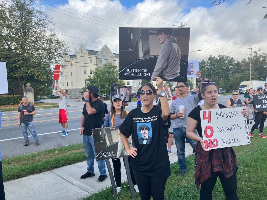 A protester holds a sign that reads "Justice for Anthony Allegrini"