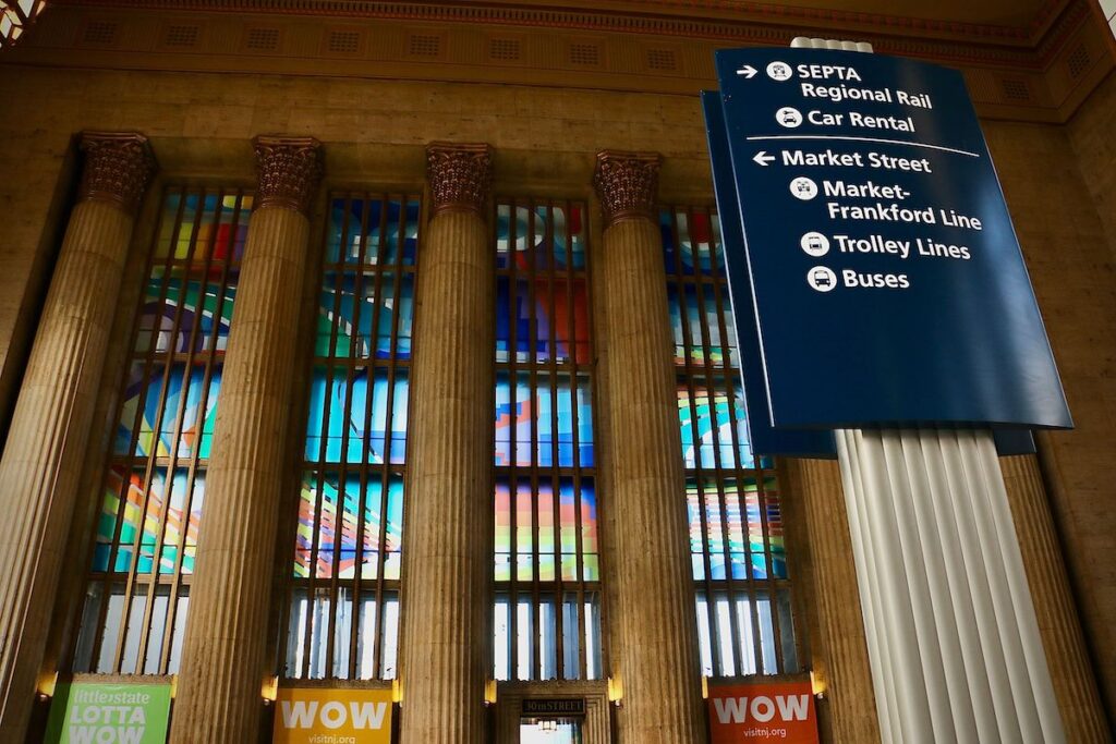 A view from below of the soaring columns and windows with vinyl panels displayed in the window.